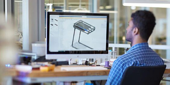 Man at desk viewing CAD image on computer screen