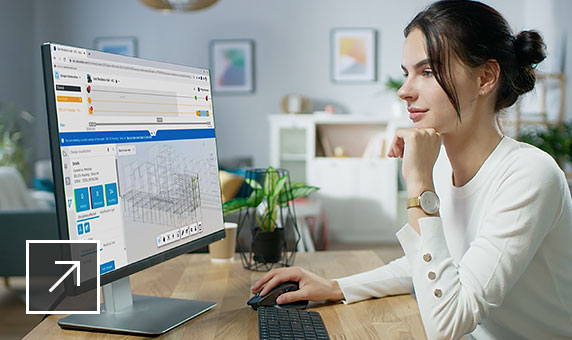 Woman sitting at a desk viewing her computer screen while using BIM Collaborate software.